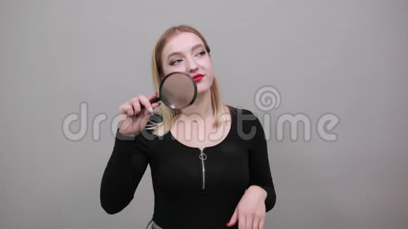 手里拿着放大镜的滑稽女人用放大镜来看视频的预览图