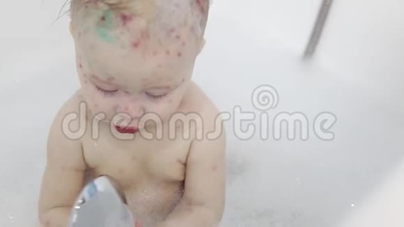 一个小女孩在用泡沫和肥皂泡洗澡一个水痘女孩在浴室洗澡视频的预览图