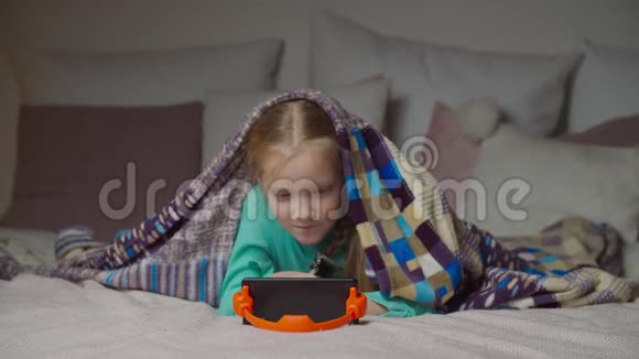 可爱的小女孩在网上看手机视频视频的预览图