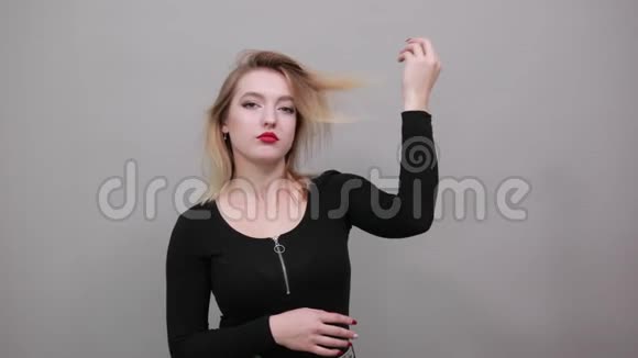 年轻的金发女孩穿着黑色夹克时尚的女人用手调整头发视频的预览图