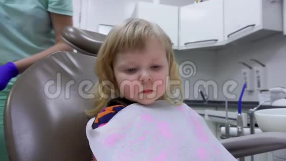 小女孩正坐在椅子上牙医正在给她看牙镜视频的预览图
