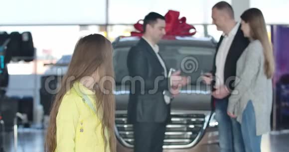 一个性格开朗的白人女孩转向相机竖起大拇指把车钥匙给父母视频的预览图