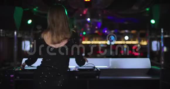 回到优雅的年轻白种人女子黑色礼服混合音乐在夜总会和舞蹈女性专业主持人视频的预览图