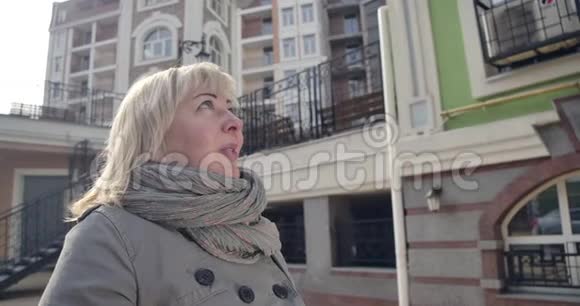 在国外城市欣赏风景的高白种人女性特写镜头站在阳光明媚的街道上积极微笑的退休人员视频的预览图