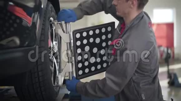 专业高加索人在维修车间使用轮对机的侧面视图自信男汽车修理工视频的预览图