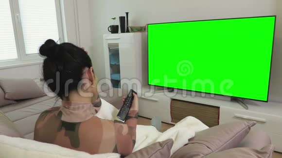 女子观看绿屏4k平板电视教练视频的预览图