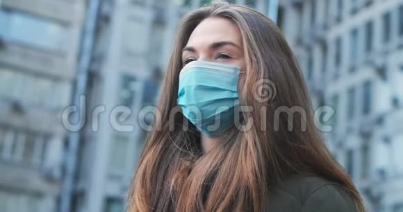 疲惫的黑发女人戴着保护面具站在户外的底部侧面白人少女的特写视频的预览图