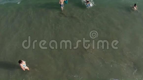 空中射击儿童在波浪上的充气甜甜圈上游泳视频的预览图