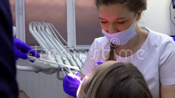 女牙医正在为病人做专业的牙科清洁视频的预览图