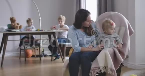 成年白种人女人和小女孩在椅子上摇摆的肖像快乐的母亲照顾她的宝贝女儿视频的预览图