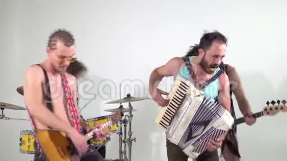 朋克摇滚乐队拍摄片段音乐家们正在用乐器跳跃贝斯手穿着女装视频的预览图