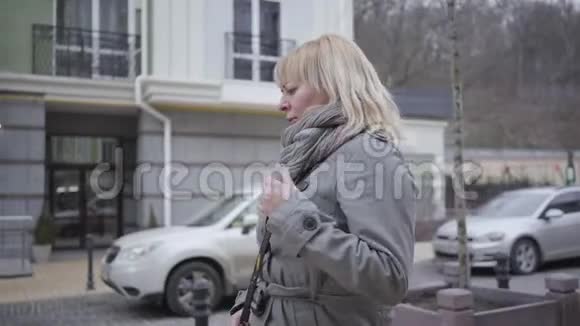 摄像机跟踪了一位在城市大街上突然心脏病发作的高加索高级女性持有的金发中年退休人员视频的预览图