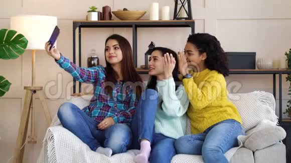 多种族女孩使用智能手机在家直播视频的预览图