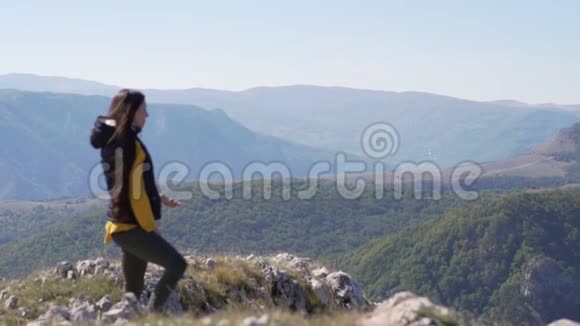 一个女孩注意力不集中从山崖扔石头视频的预览图