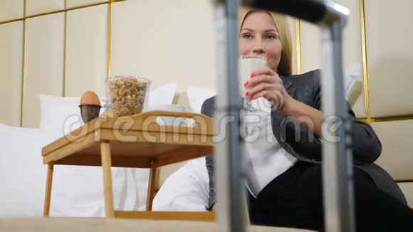 女商务旅行者在酒店房间的肖像从手提箱手柄上拍摄的录像豪华酒店的女人视频的预览图