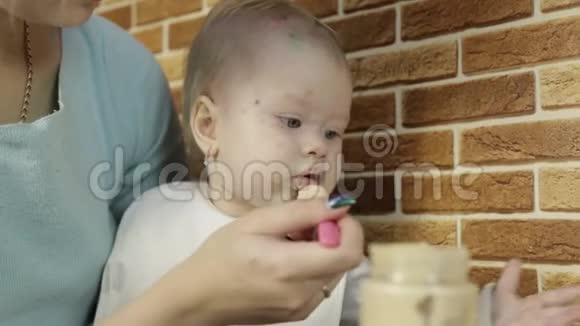 快乐的母亲用勺子喂粥给家里的小女儿小女孩有水痘视频的预览图