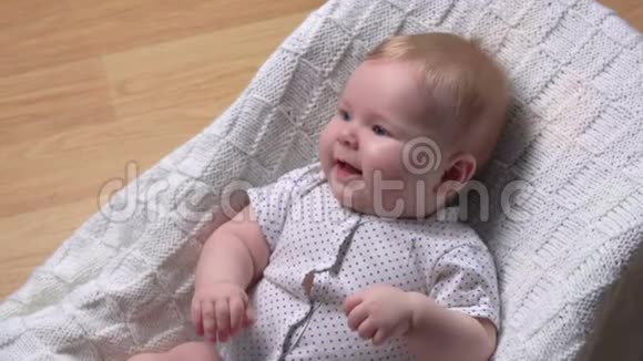 可爱的宝宝躺在婴儿椅上开心地笑视频的预览图