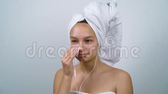 开朗的少女洁面沐浴后听音乐视频的预览图