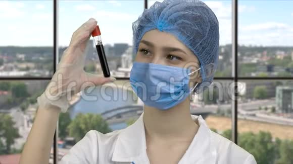 一位年轻女医生观察血液试管的肖像视频的预览图