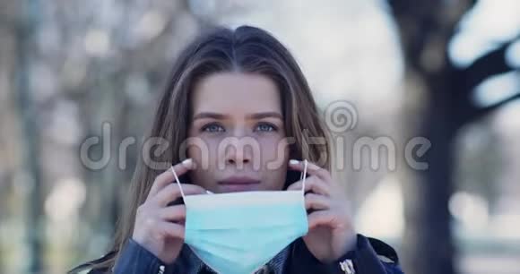 为冠状病毒防护戴上口罩的年轻女子视频的预览图