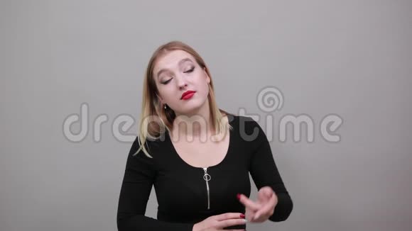 穿夹克衫的女孩灰色背景困惑的女人扭食指寺庙视频的预览图