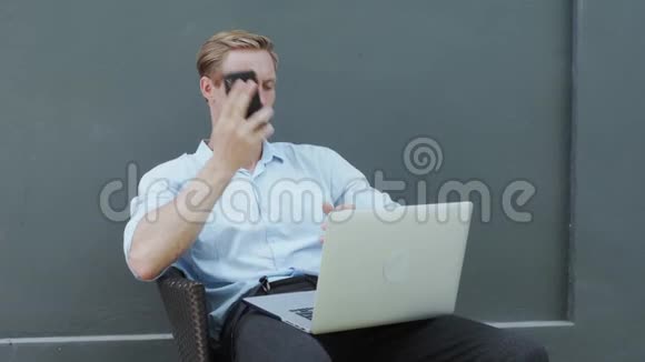 商务人士手提电脑打电话帅哥讲手机视频的预览图