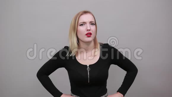 身穿黑色夹克衫的金发少女吓得女人用手打手势视频的预览图