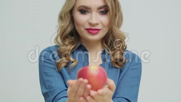 可爱的女人在一张桌子上拿着一个苹果背景是水果和蔬菜视频的预览图