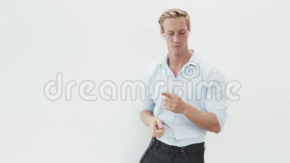 穿衬衫的男人用无线耳机听音乐跳舞白底视频的预览图