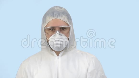 年轻人穿着带口罩和眼镜的抗病毒防护服视频的预览图