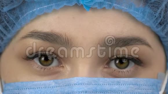 年轻女外科医生或戴防护面罩和帽子的实习生的闭眼视频的预览图