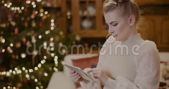 女人在圣诞节用数码平板电脑视频的预览图
