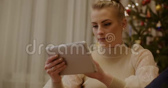 女人在圣诞节用数码平板电脑视频的预览图