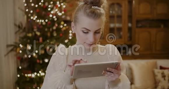 圣诞节期间使用数码平板电脑和网上购物的女人视频的预览图