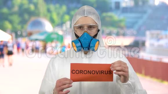 戴呼吸面罩和防护服的人敦促人们小心冠状病毒视频的预览图