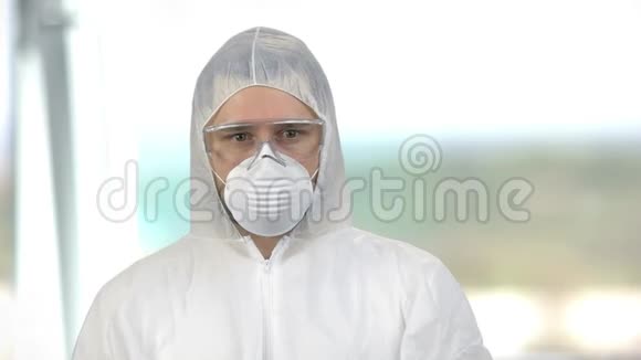 戴白色防护服戴口罩和眼镜的人的肖像视频的预览图
