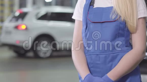 无法辨认的女汽车修理工拿扳手年轻的白人妇女穿着工作服站在修理店里职业视频的预览图