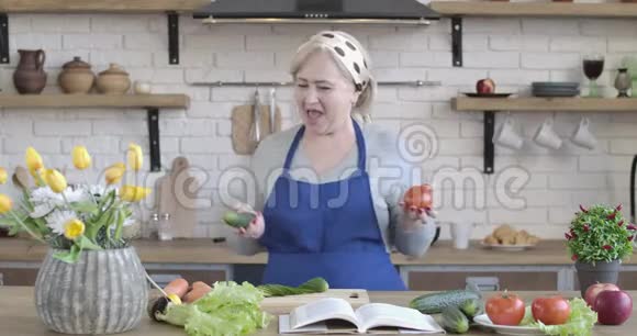 漂亮的高白种人女人闻着新鲜蔬菜开始在家做沙拉快乐女性肖像视频的预览图