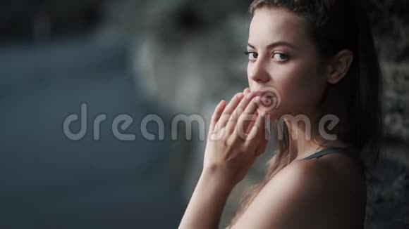 性感年轻女人的肖像穿过头发看镜头视频的预览图