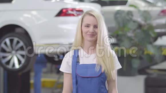 性格开朗的白种人女人站在汽车的背景下向镜头展示汽车钥匙女汽修工视频的预览图