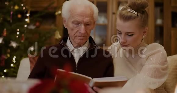 孙女和外祖父在家看相册视频的预览图