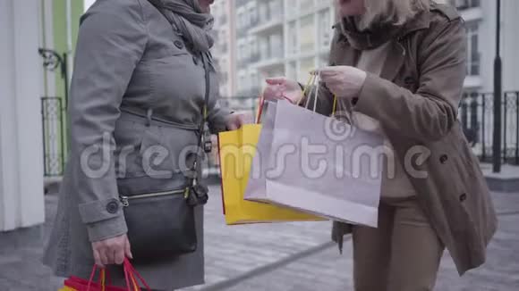无法辨认的白种人成熟的女人向朋友展示购买和在城市街道上跳舞退休人员快乐视频的预览图