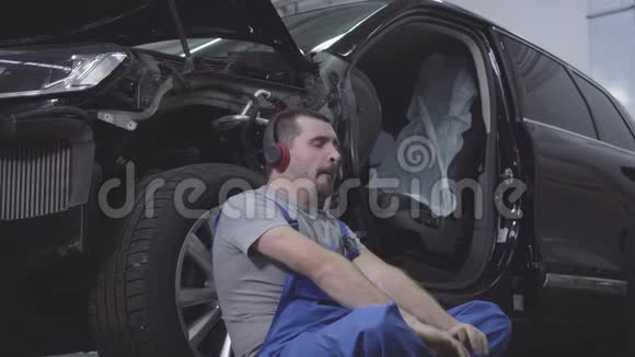 疲惫的白种人打哈欠的肖像靠在汽车轮上闭上眼睛厌倦了专业人士视频的预览图