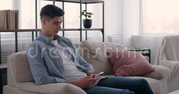 年轻人在家里用手机和朋友聊天视频的预览图
