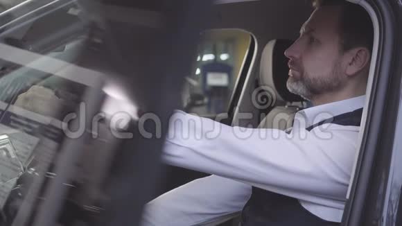 侧面看自信的白种人男人坐在司机座位上看着远处成功的商人开车视频的预览图