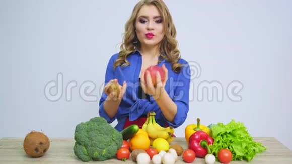 一个女人在一张桌子上拿着一个苹果背景是水果和蔬菜视频的预览图