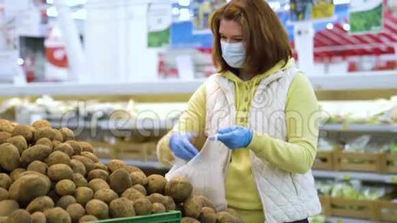 在大流行病期间在杂货店摘土豆用面具的年轻妇女视频的预览图