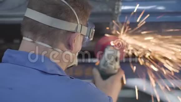 用金属磨床对男性白种人工人进行后视特写在汽车修理厂工作的专业人士视频的预览图