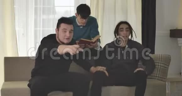 三个白人成年学生在电视上看体育比赛的肖像足球迷在感情上做手势视频的预览图