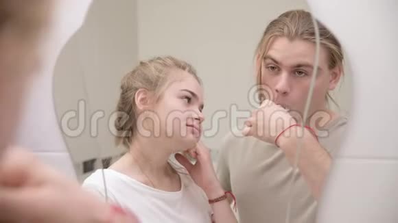 一对在浴室里照镜子男人刷牙特写视频的预览图